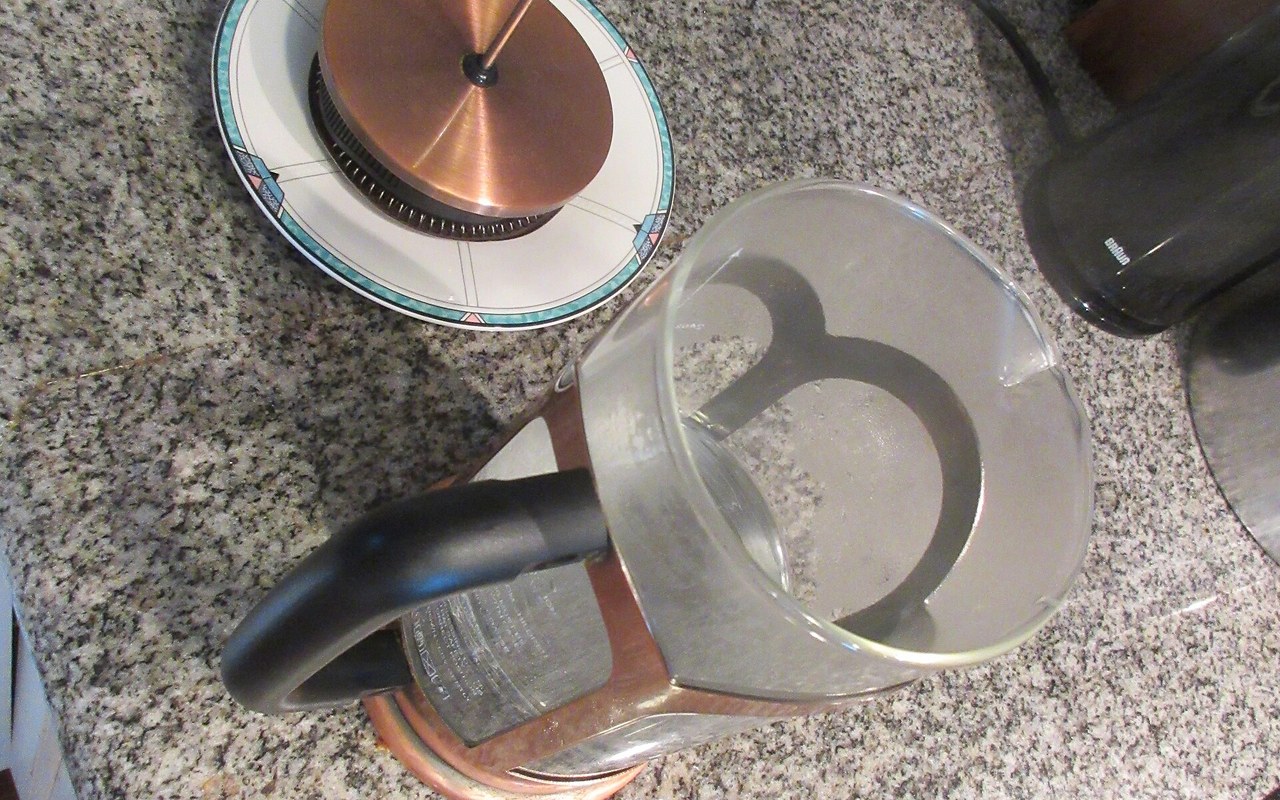 French press being plunged with brewed coffee